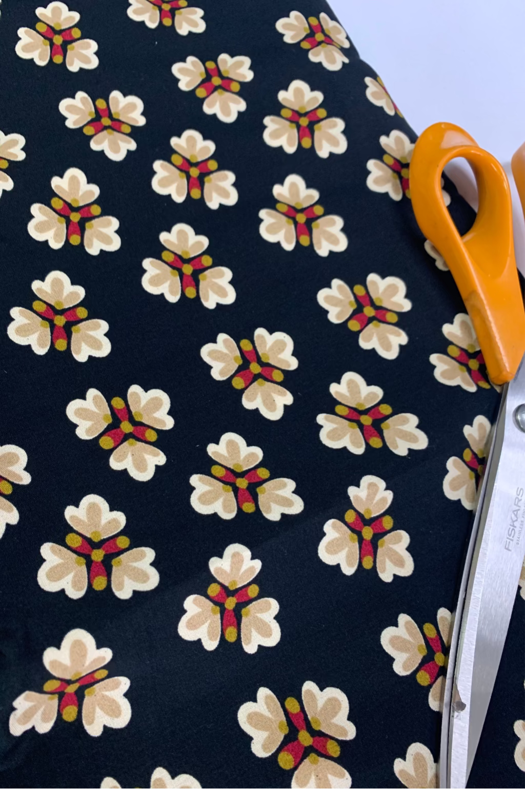 Fabric with floral pattern and scissors on a white background