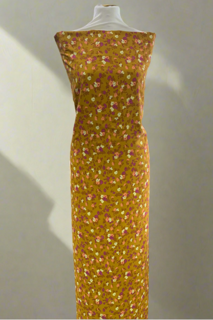 Yellow floral dress on a mannequin in a store setting.