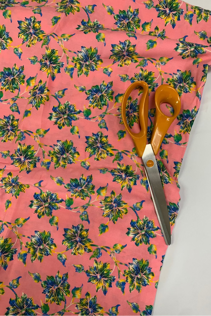 Floral-patterned fabric with scissors on a white background
