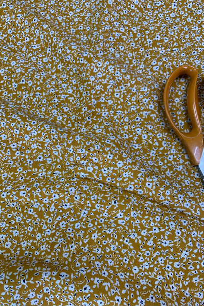 Floral-patterned fabric with a pair of scissors on top