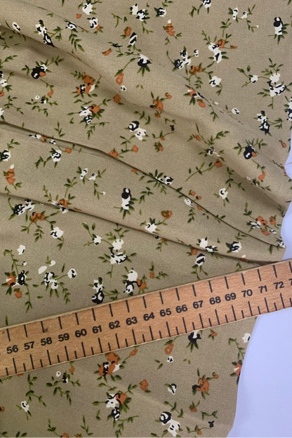 Fabric with small floral pattern and ruler for scale on a beige background