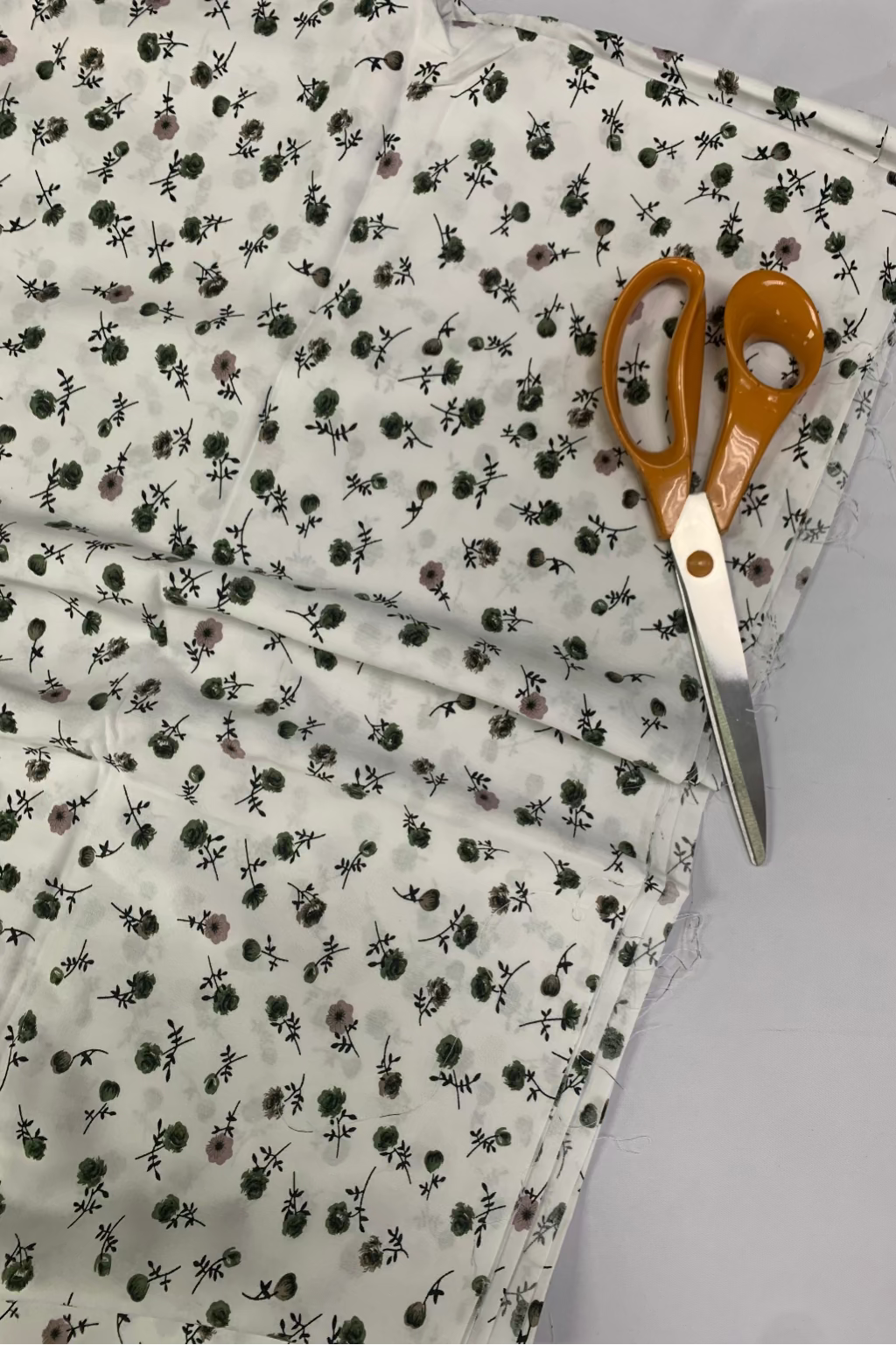 Floral-patterned fabric with scissors on a gray background