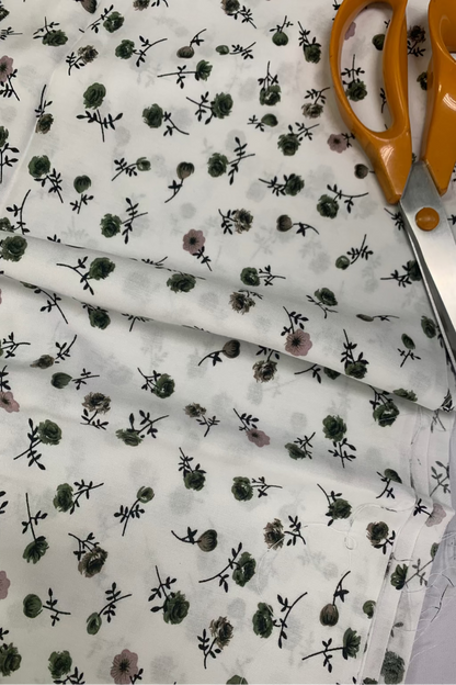 Floral-patterned fabric with scissors on a light gray background