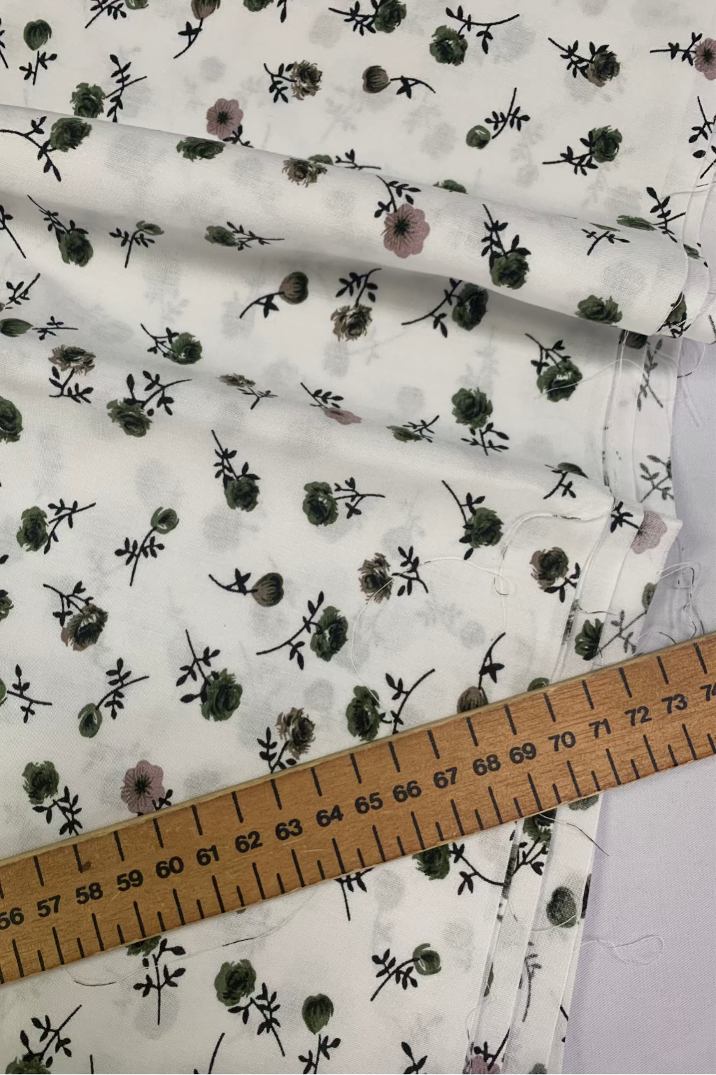 Floral patterned fabric with a ruler for scale on a white background