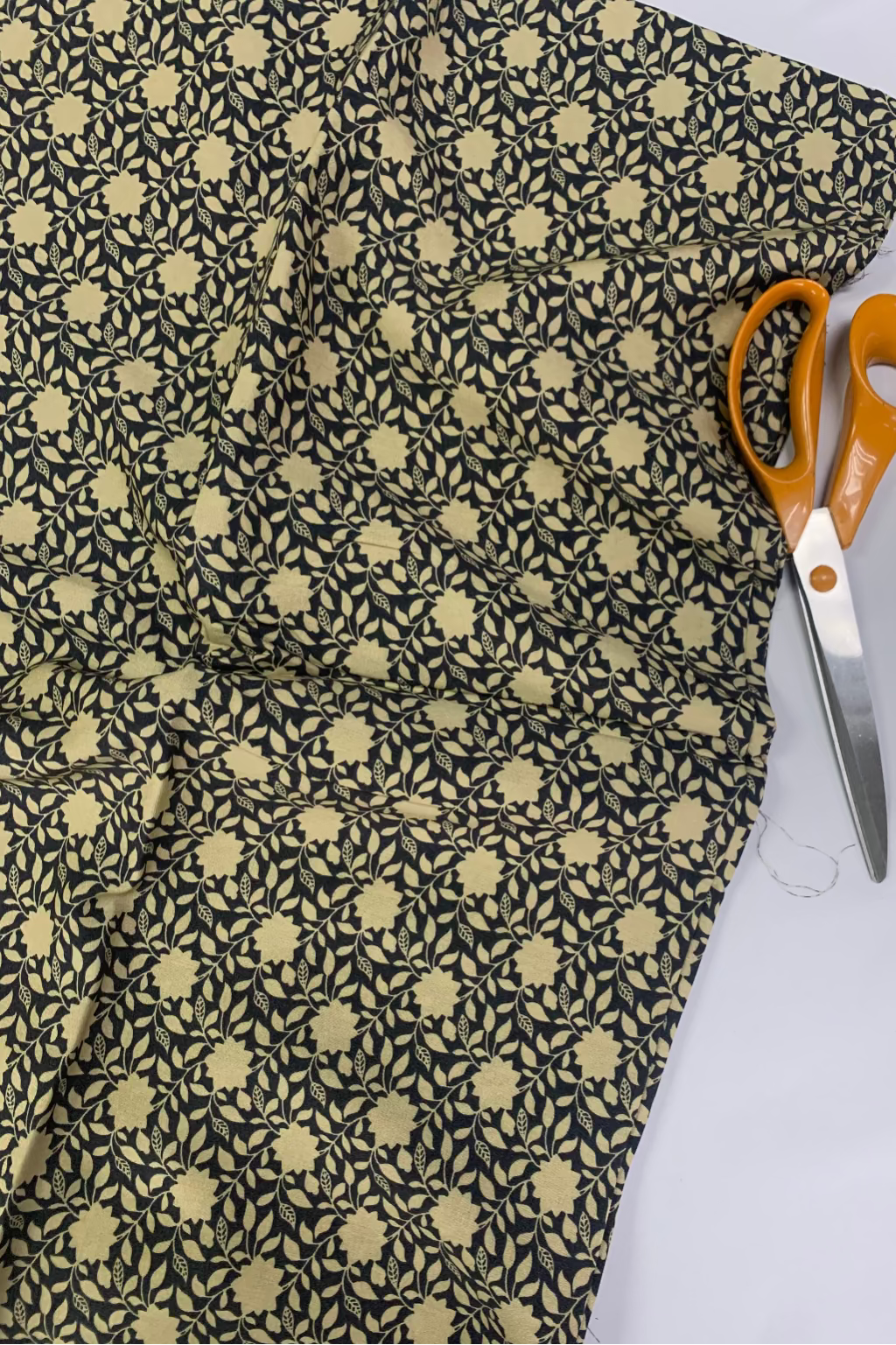 Floral-patterned fabric with scissors on a white background