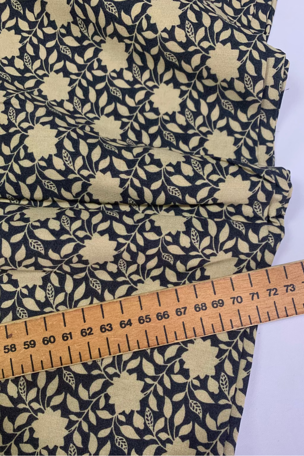 Floral fabric with a ruler for scale on a white background