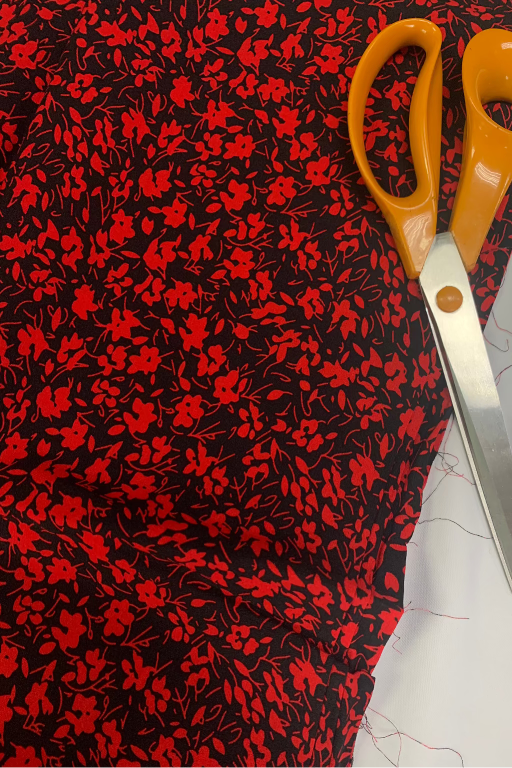 Scissors on a piece of red and black floral fabric