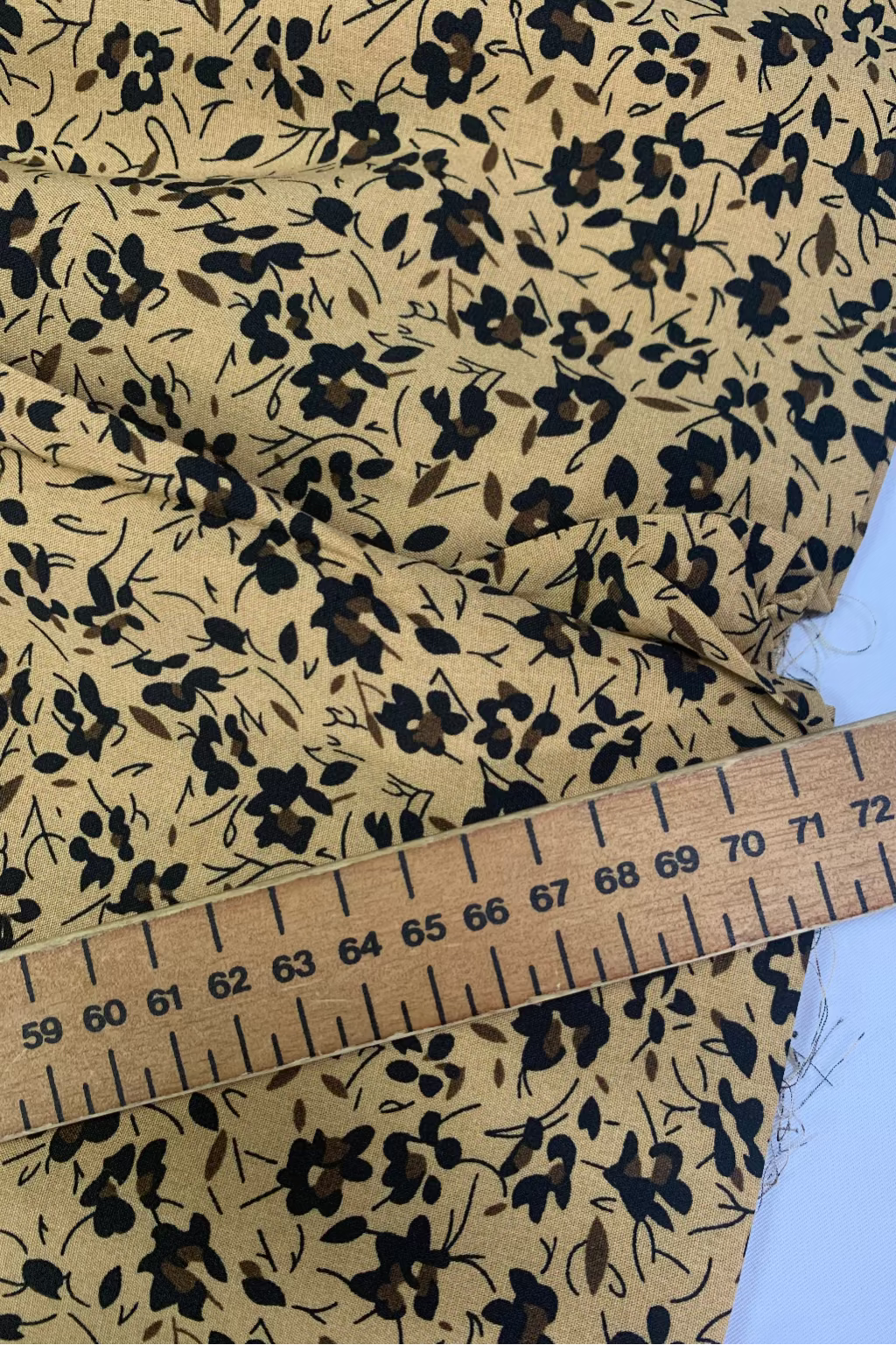 Floral fabric with a ruler for scale on a light blue background