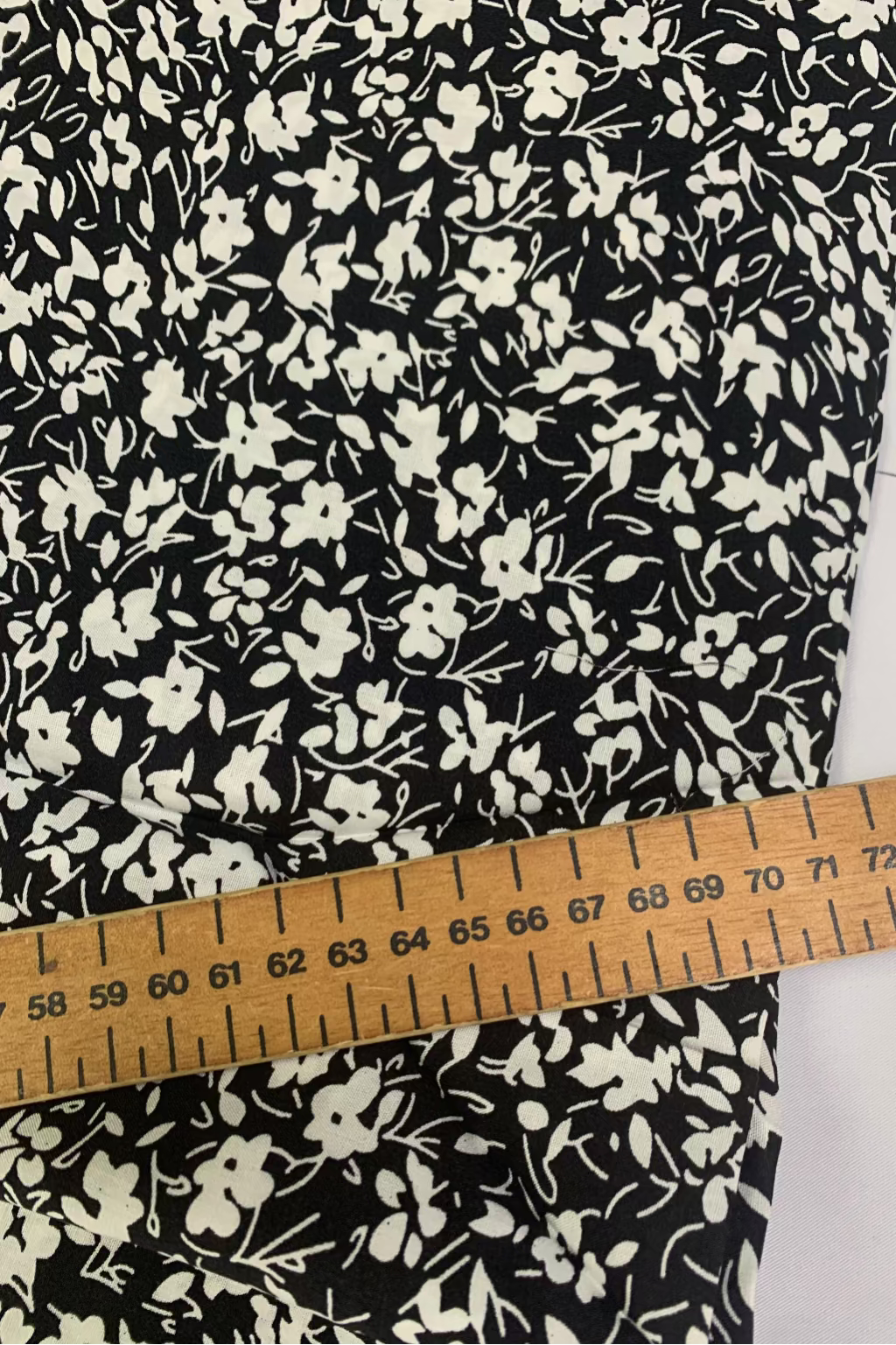 Floral fabric with a ruler for scale on a white background