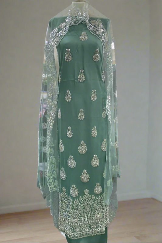 Green fancy party dress on a mannequin in a store setting