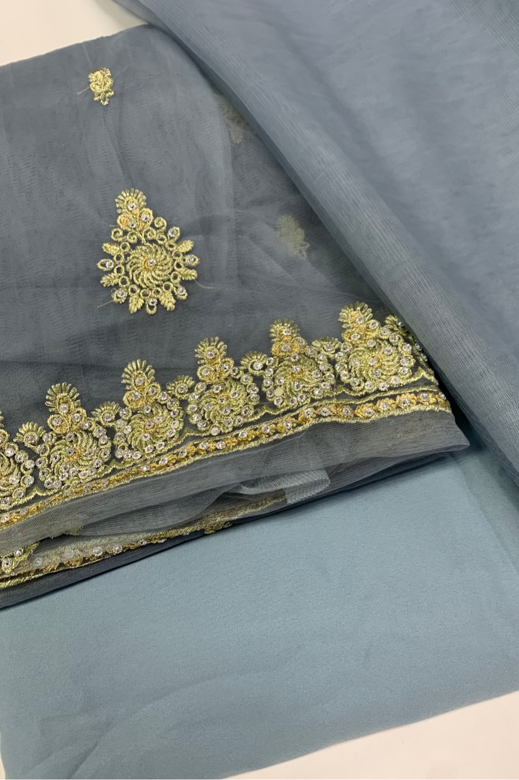 Gray fabric with gold embroidery on a white background