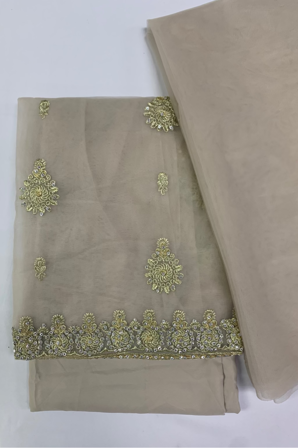 Beige fabric with gold embroidered patterns on a white background