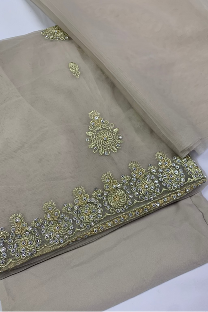 Beige fabric with intricate gold embroidery on a white background