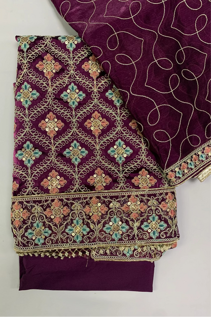 Purple fabric with intricate gold and multicolor embroidery on a white background