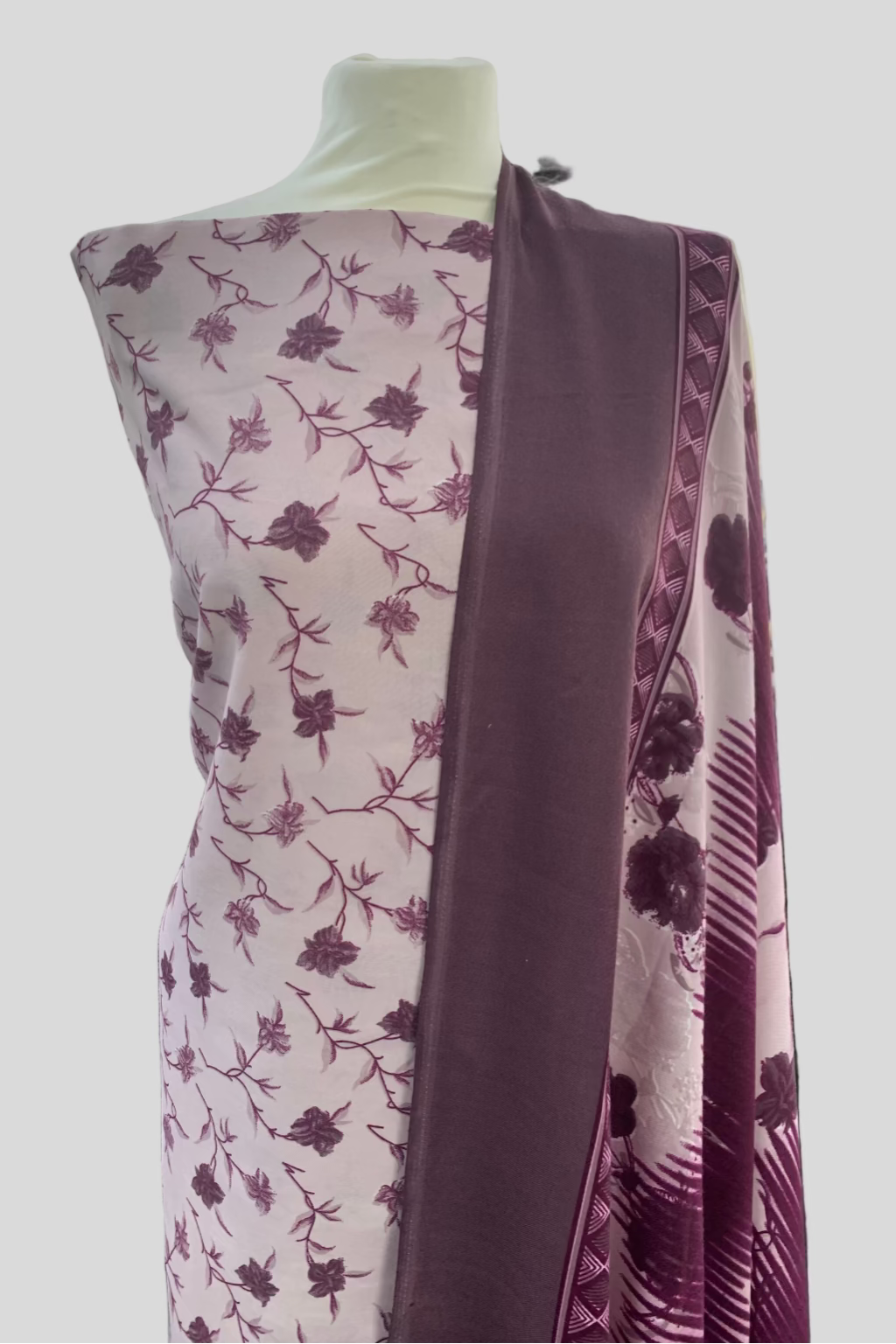 Mannequin wearing a floral-patterned fabric in a fabric store.