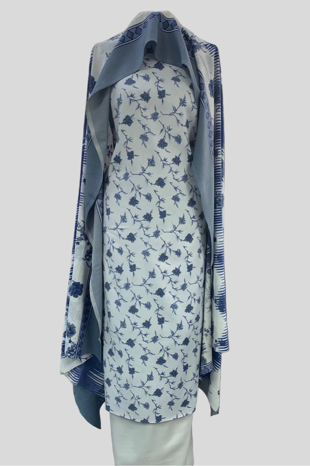 Floral dress with blue accents on a mannequin in a store setting