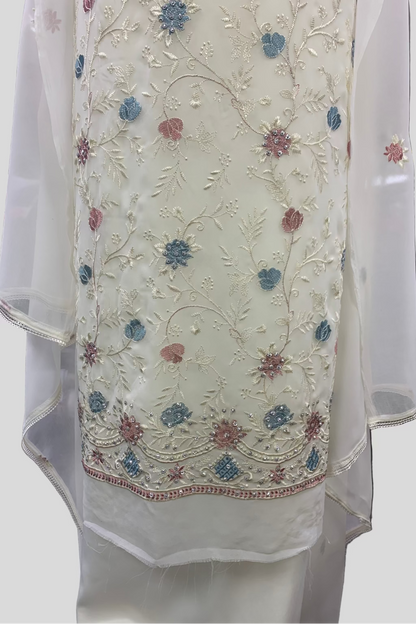White embroidered garment with floral patterns on a plain background