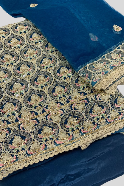 Teal fabric with intricate gold embroidery on a white background