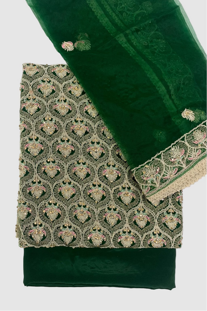 Green fabric with intricate gold embroidery on a white background