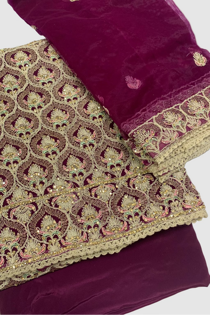 Purple fabric with intricate gold embroidery on a white background