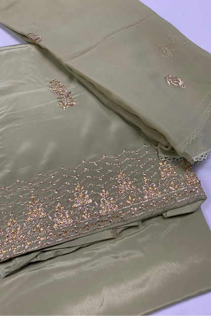Green fabric with gold embroidery on a white background