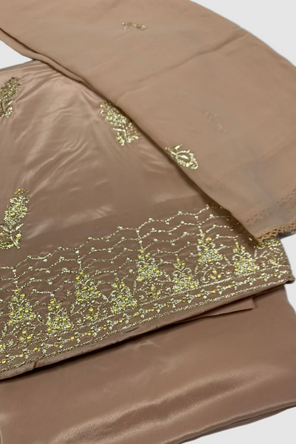 Peach fabric with gold embroidery on a white background