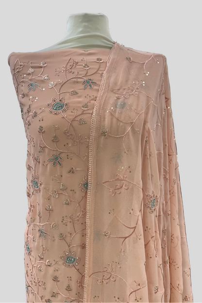Peach embroidered fabric on a mannequin in an indoor setting
