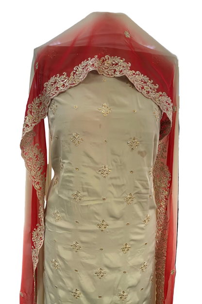 Traditional embroidered garment with red border in a store setting