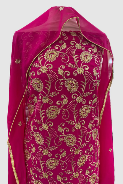 Pink fabric with gold floral patterns in a store setting