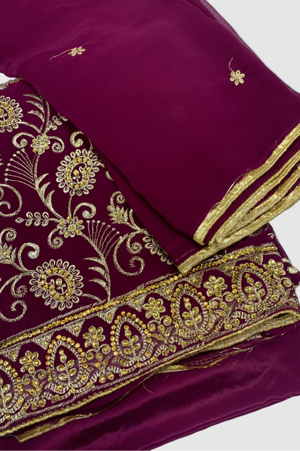 Maroon fabric with gold embroidery on a white background