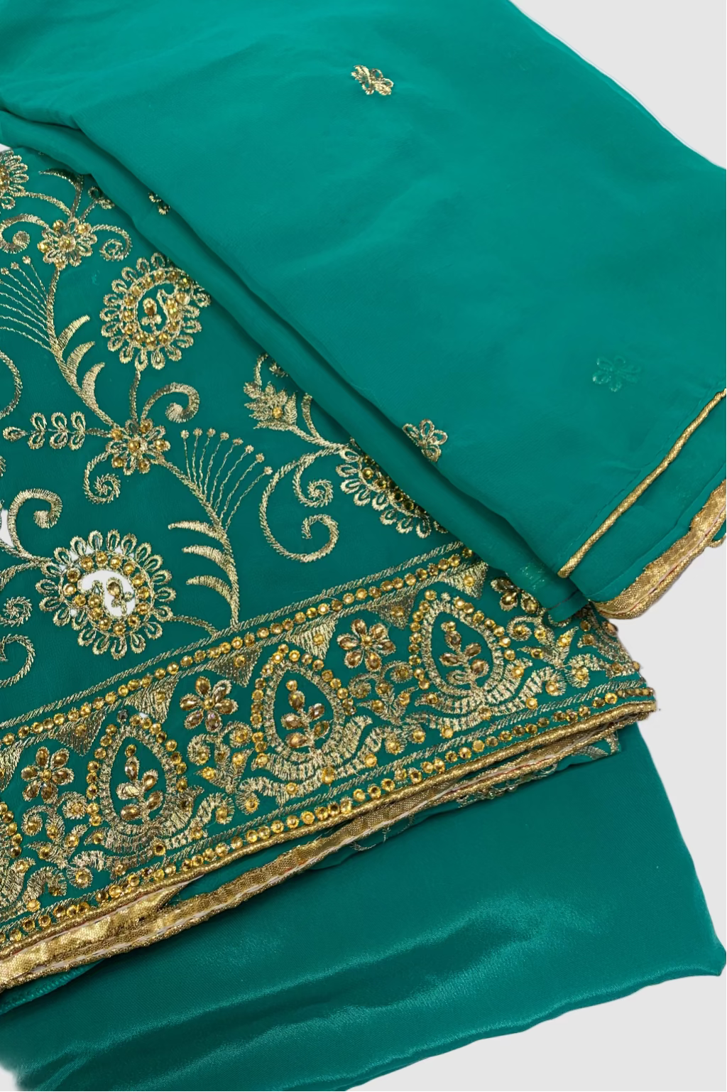 Green fabric with gold embroidery on a white background