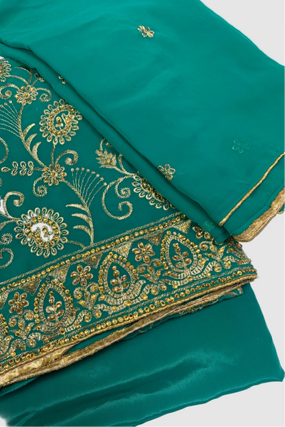 Green fabric with gold embroidery on a white background