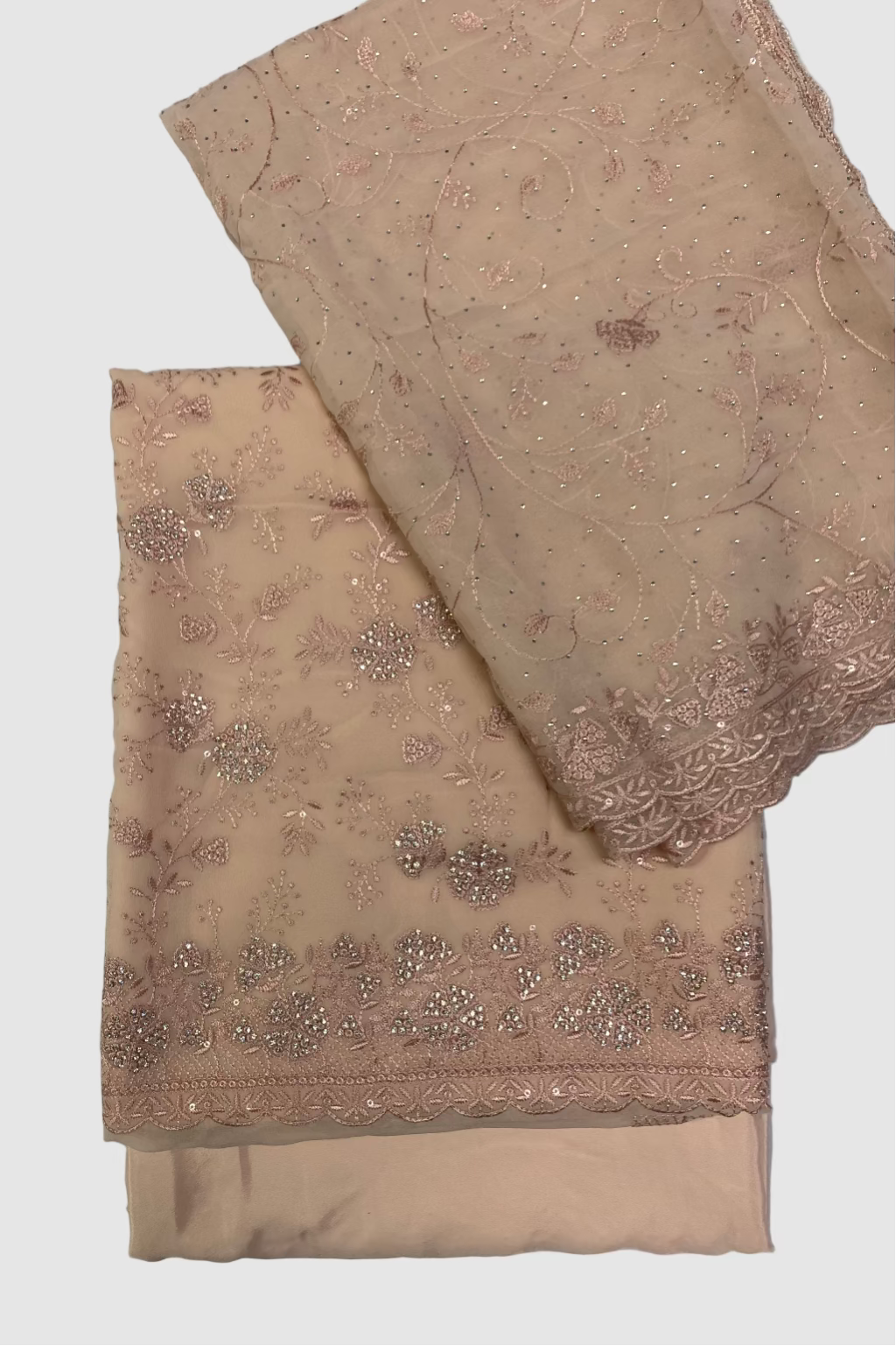 Peach fabric with intricate beadwork on a white background