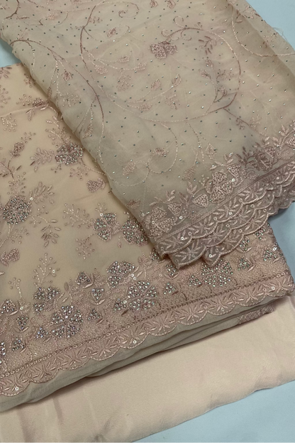 Peach fabric with intricate floral embroidery on a white background