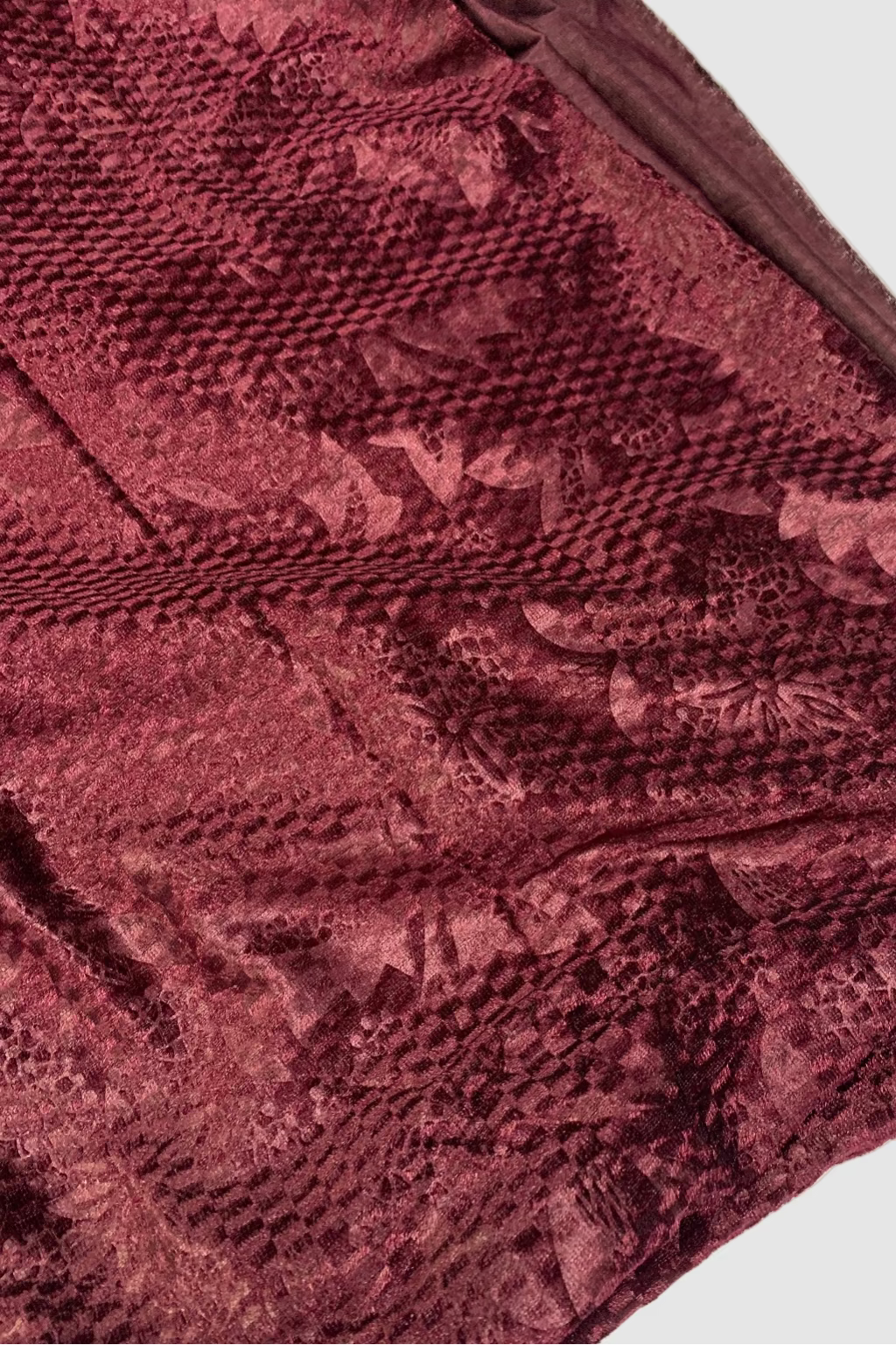 Close-up of a textured burgundy fabric with a subtle pattern.