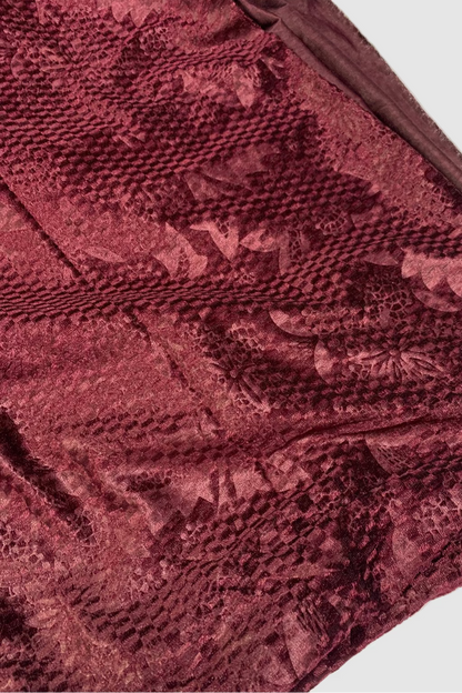 Close-up of a textured burgundy fabric with a subtle pattern.
