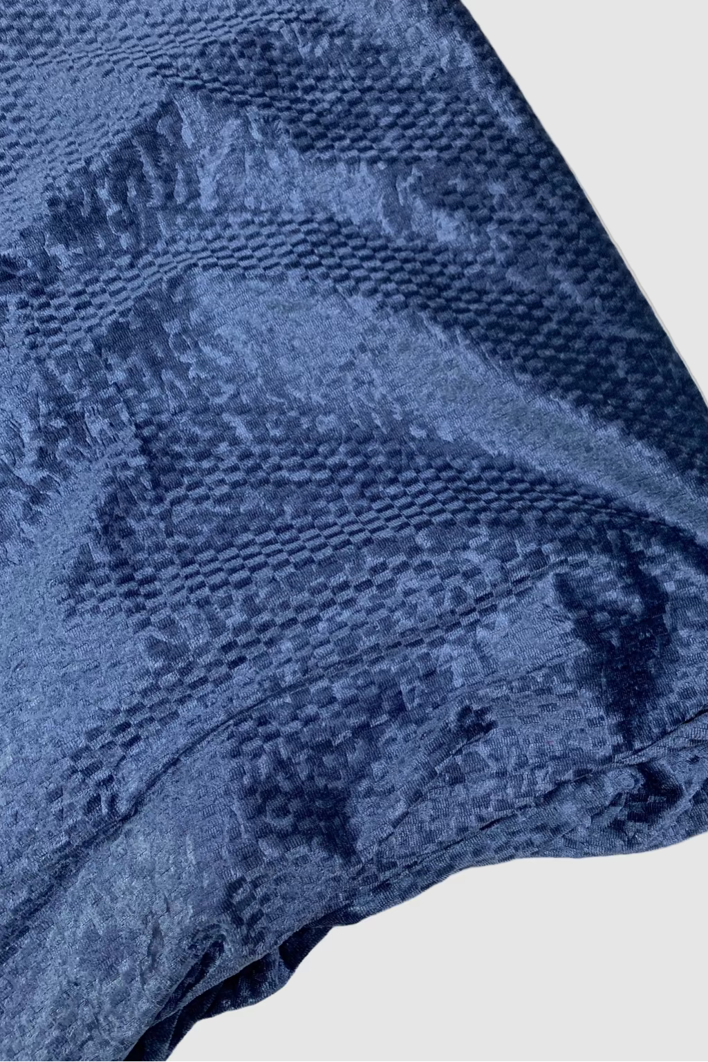 Close-up of a textured blue fabric on a white background