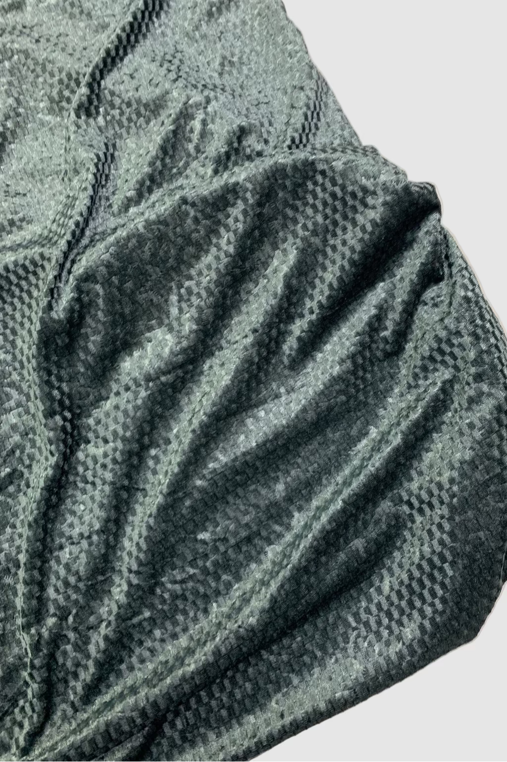 Textured green fabric on a beige background