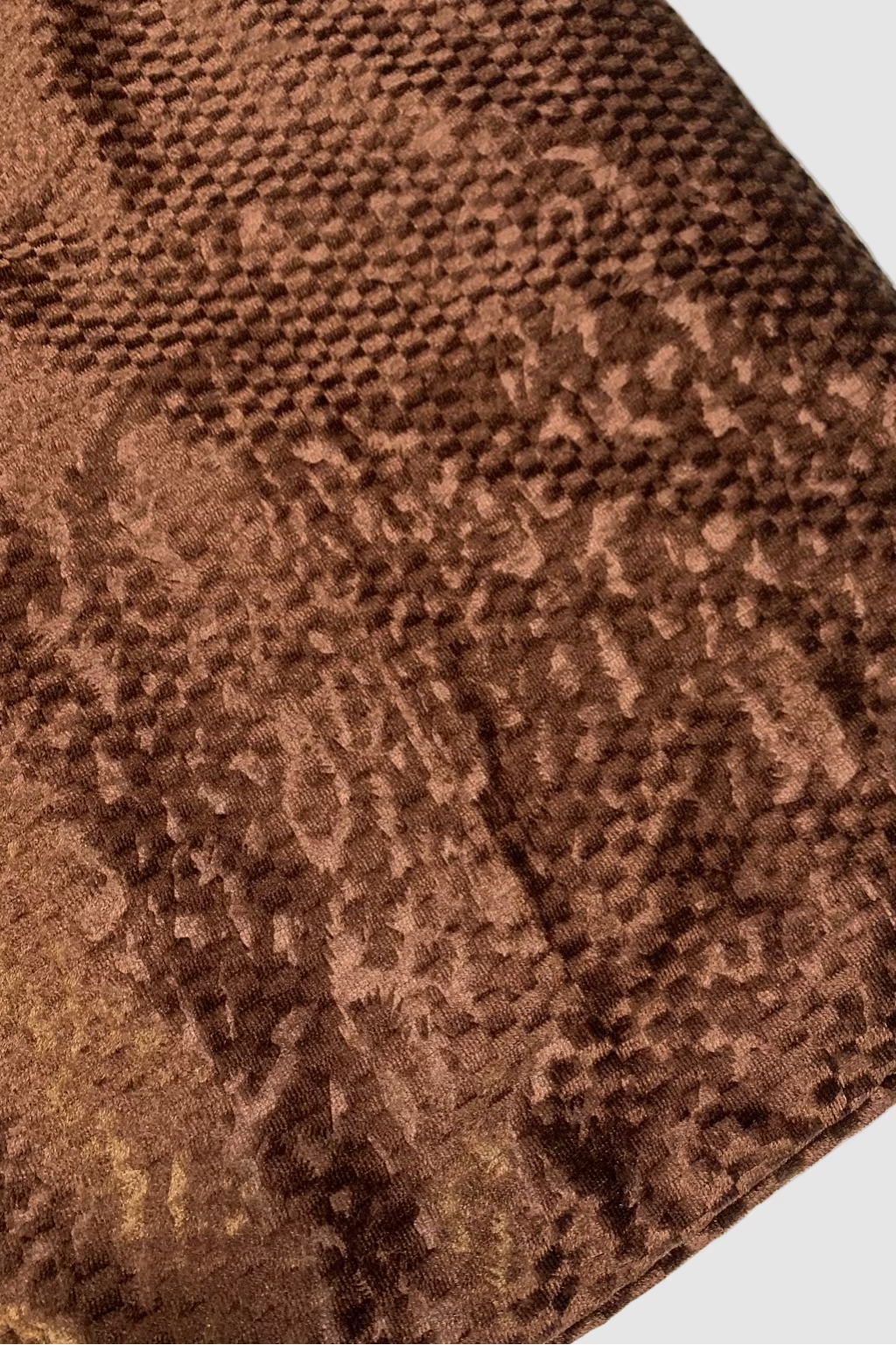 Close-up of a brown textured fabric with a subtle pattern on a white background