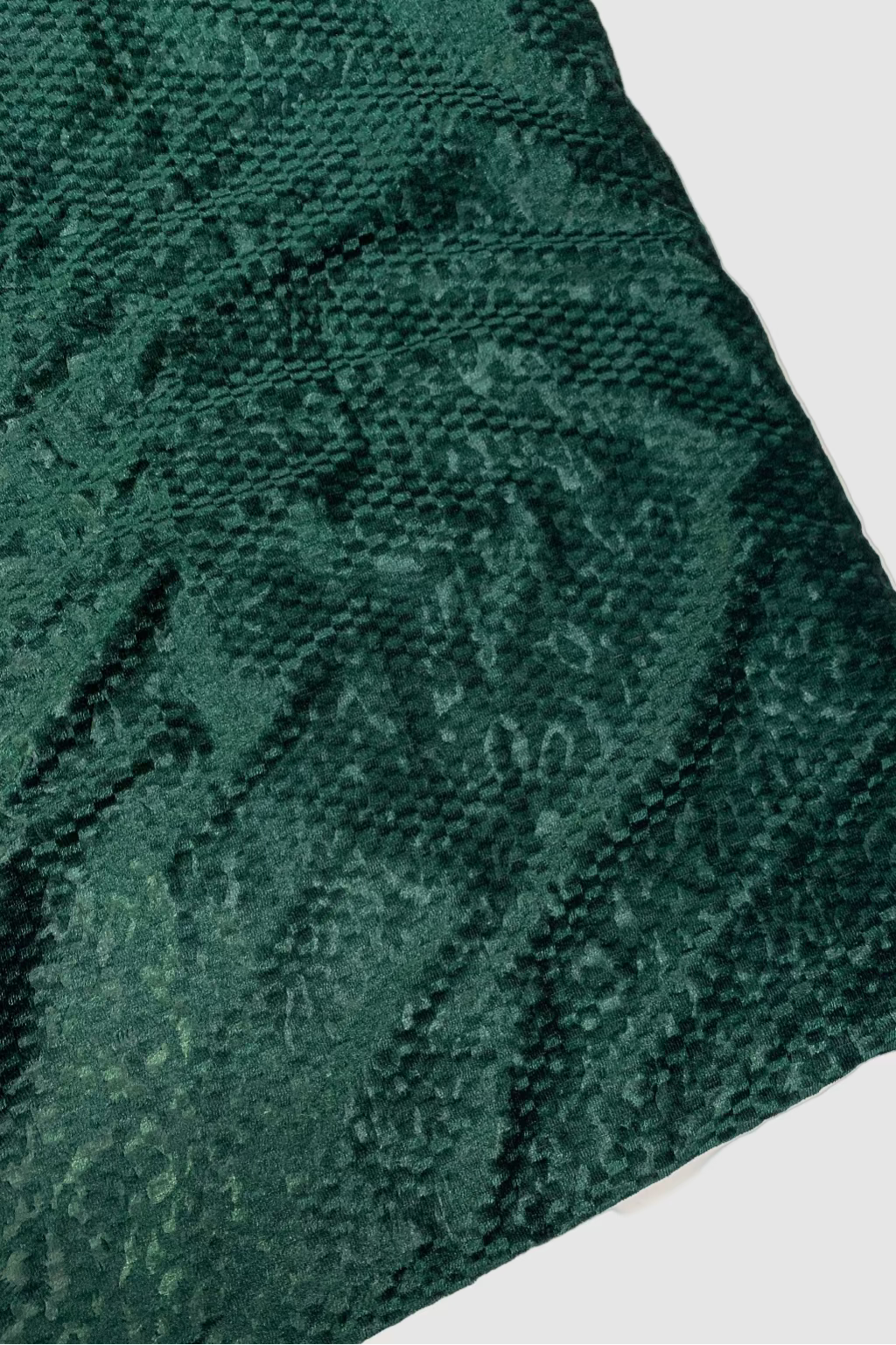 Textured green fabric on a beige background