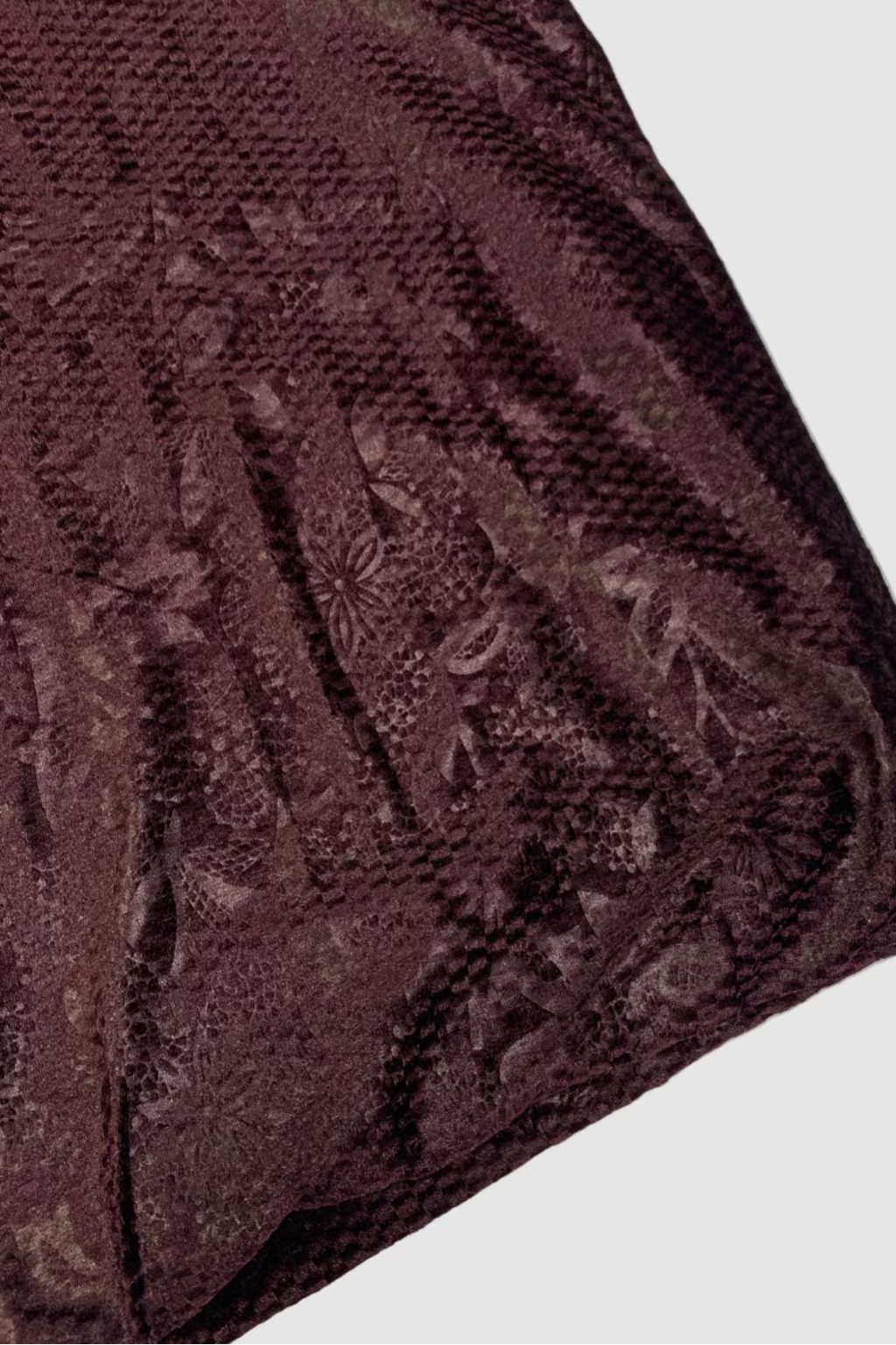Purple textured fabric with floral patterns on a light background