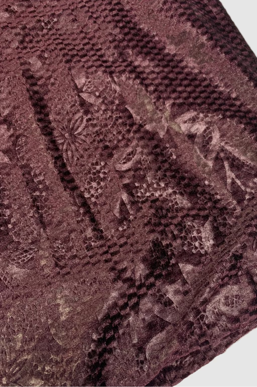 Close-up of a textured purple fabric with floral patterns