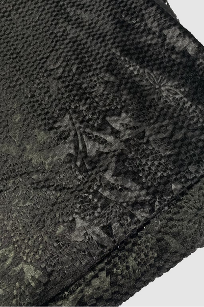 Textured black fabric with floral pattern on a white background