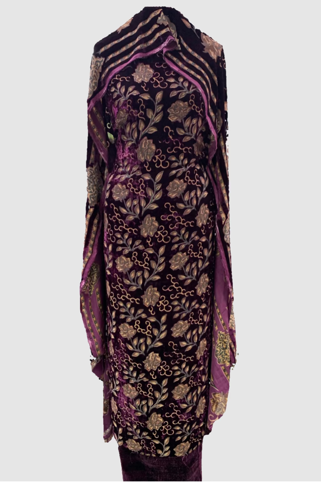 Purple embroidered traditional outfit on a mannequin in a store setting.