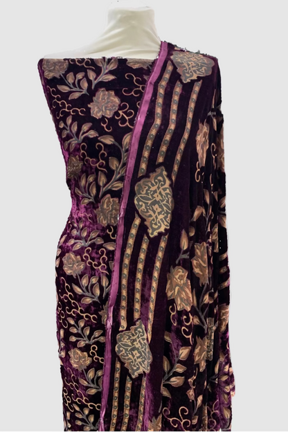 Decorative fabric with intricate patterns on a mannequin in a store setting.