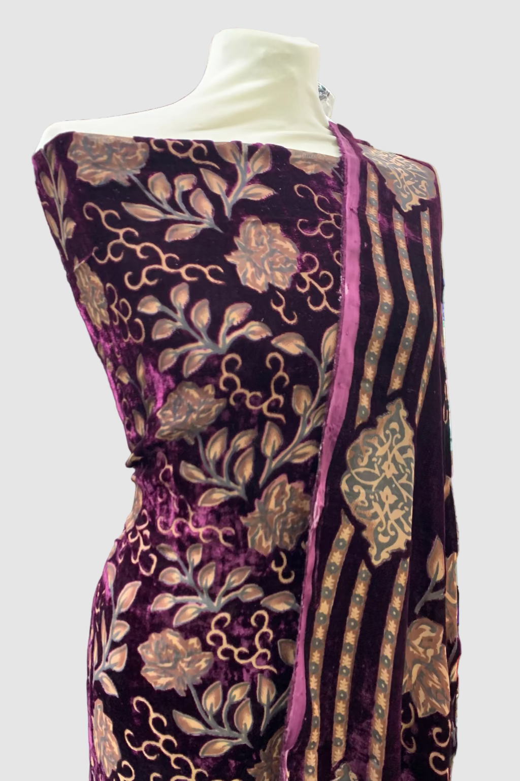 Mannequin wearing a purple printed garment in a store setting