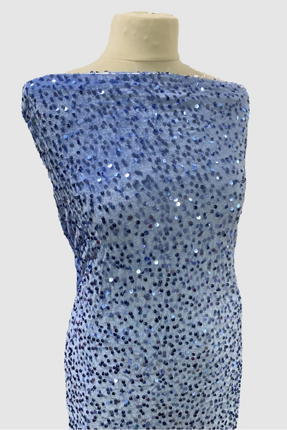 Mannequin wearing a blue sequin fabric in a fabric store setting