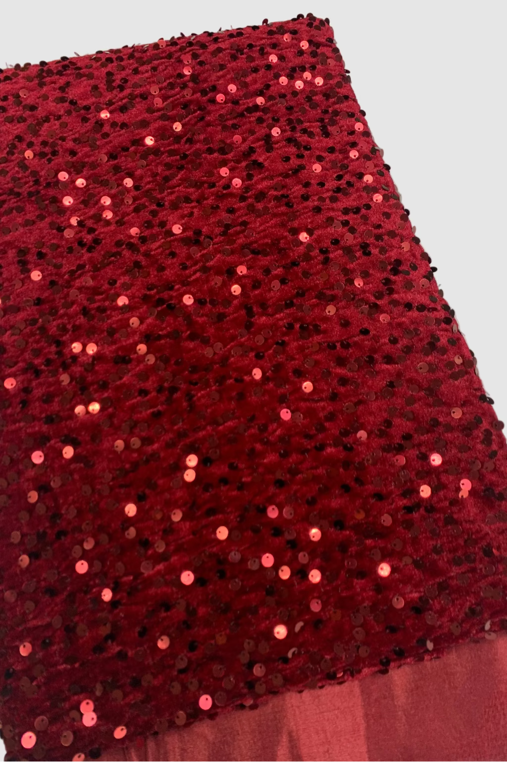 Red sequin fabric on a plain background