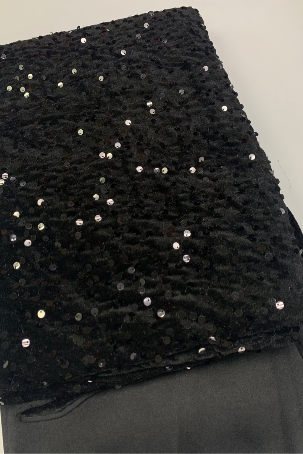 Black velvet fabric with sequin on a light gray background