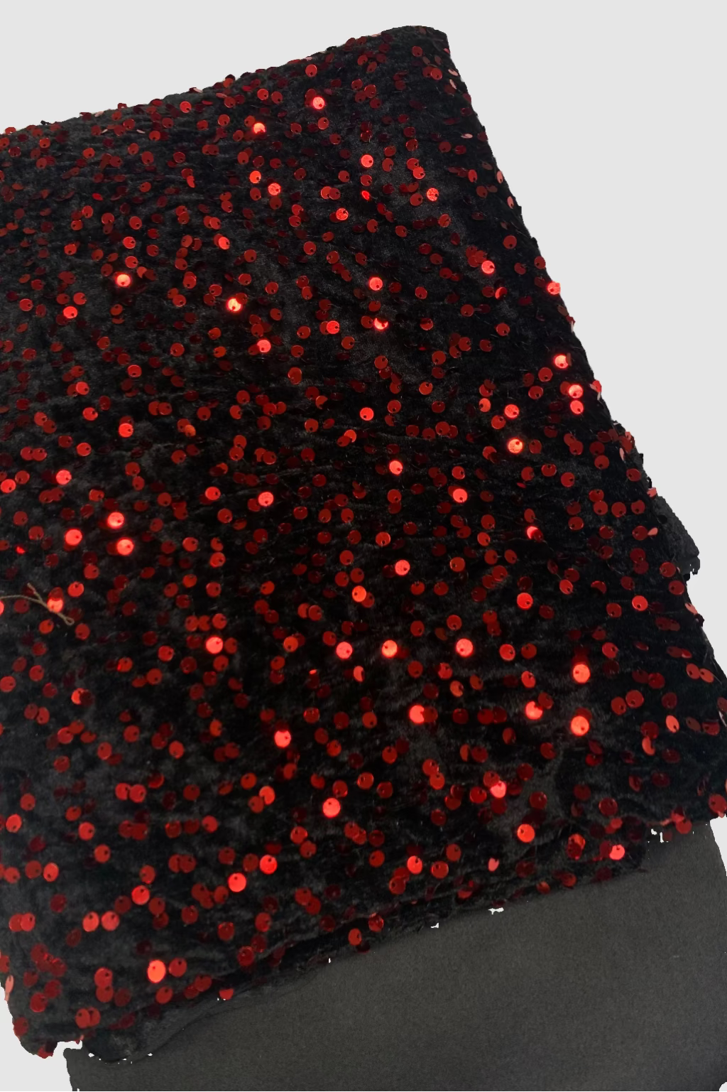 Black fabric with red sequins on a white background